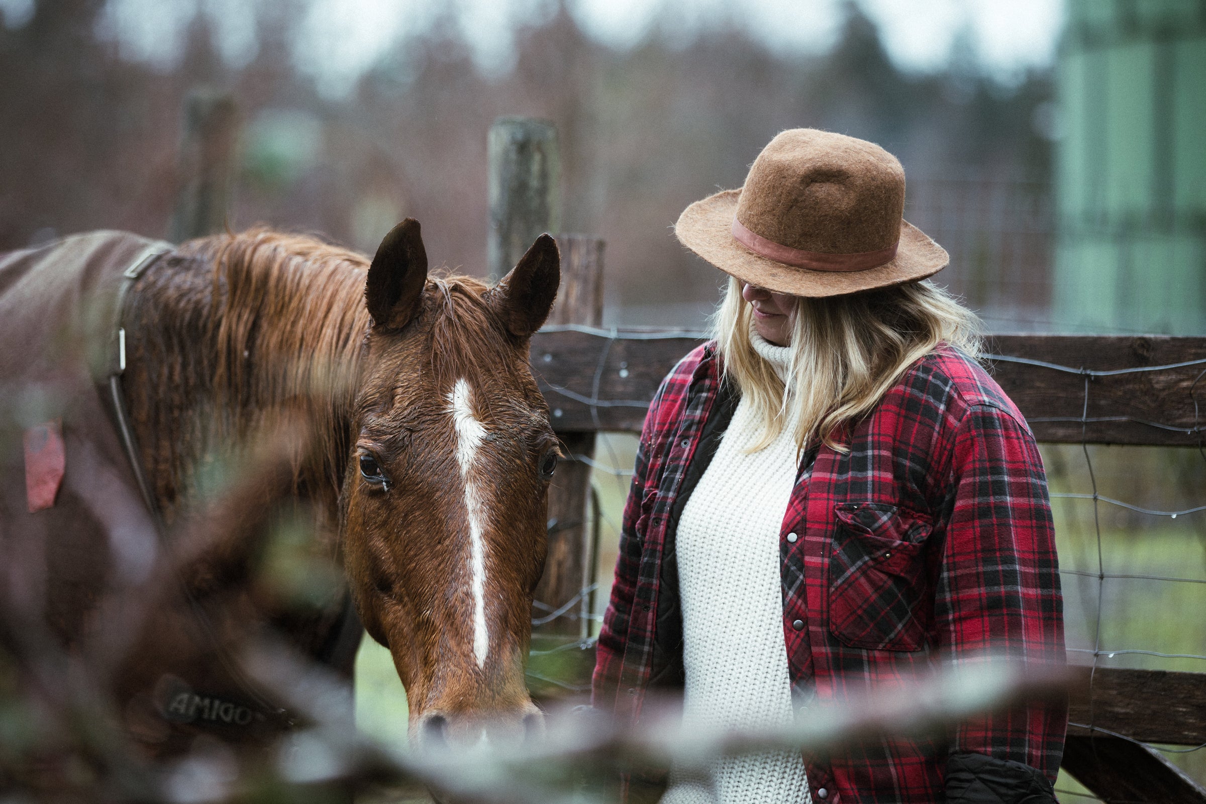 women in red jacket with horse wearing hat 